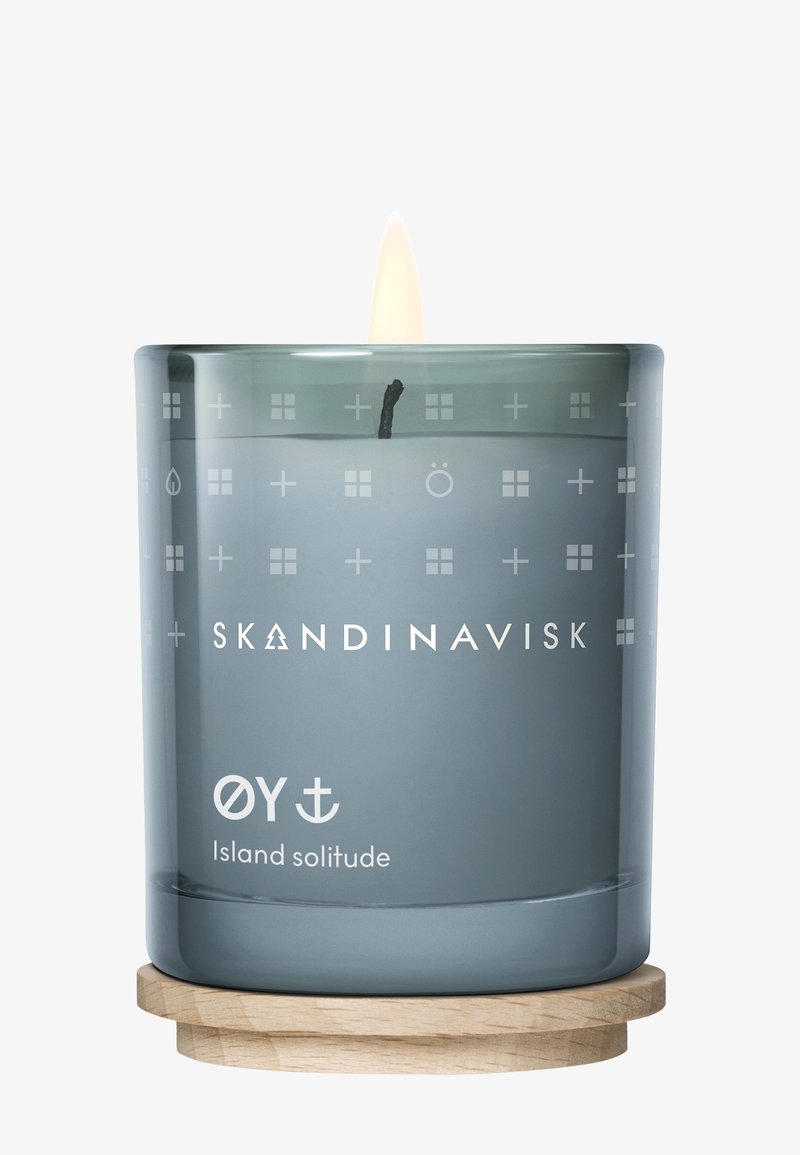 Skandinavisk candle in a translucent grey glass container with white geometric patterns. Includes a wooden base and a lit wick.