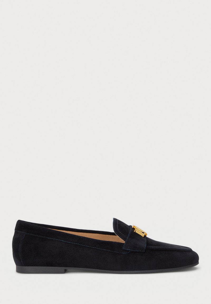 Marineblauwe suède loafers met een ronde neus, leren voering en een gouden metalen accent op het bovenwerk. Platte zool, minimalistisch ontwerp.