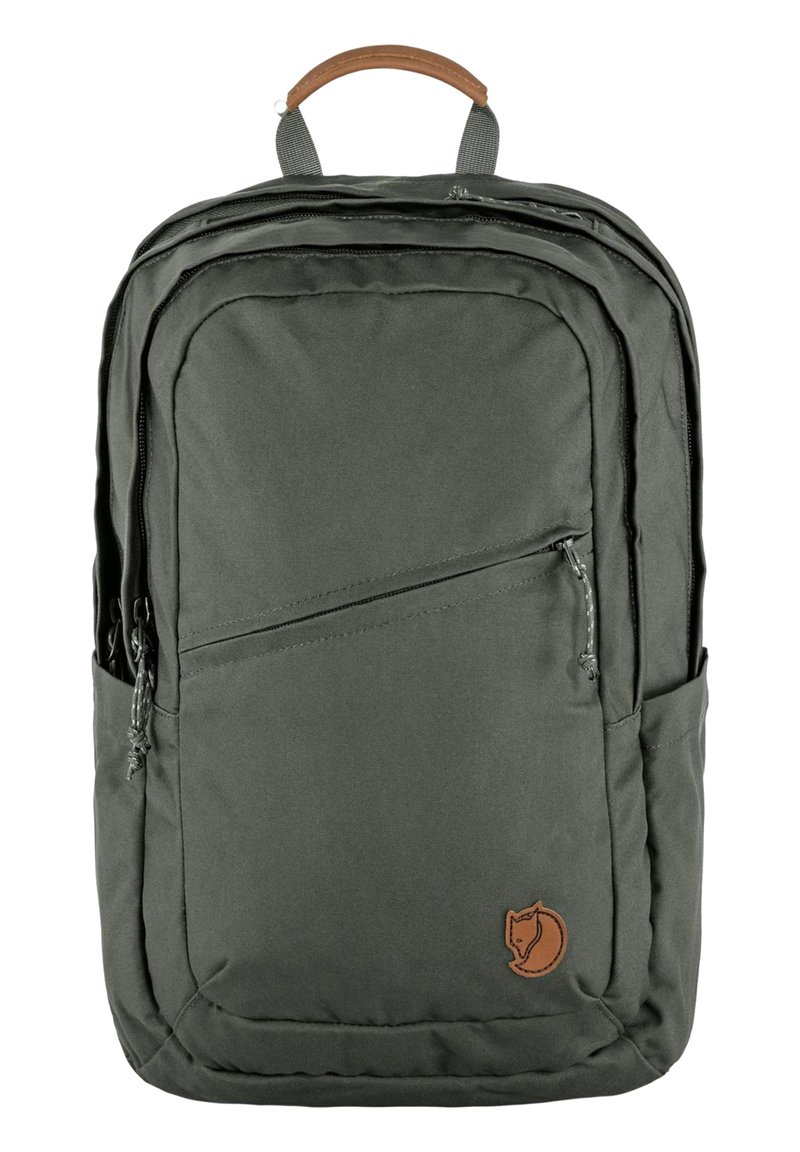 Mochila de tela verde con un asa de cuero marrón, múltiples compartimentos con cremallera, bolsillos laterales y un parche con un logotipo que presenta un zorro estilizado.