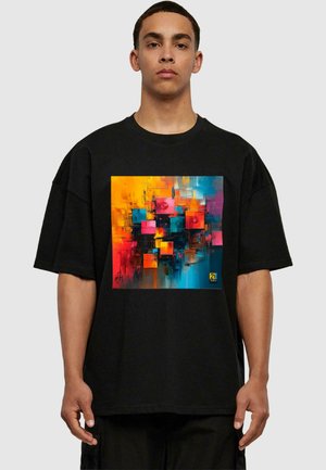 Sort oversized t-shirt med et farverigt abstrakt design med firkanter i orange, pink, blå og sort. Blødt stof og afslappet pasform.