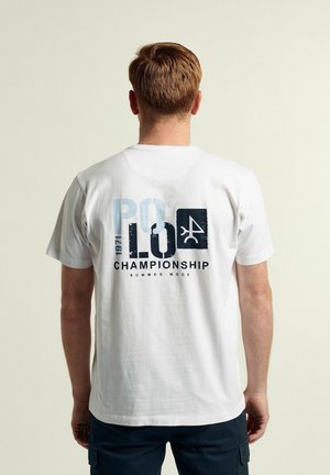 Camiseta de algodón blanca con un estampado gráfico en la parte posterior que incluye texto en azul y negro, incluyendo "POLO 1971 CAMPEONATO MODE VERANO".