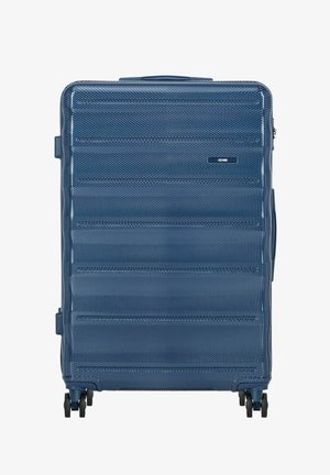 Duża niebieska twarda walizka z teksturowaną powierzchnią, poziomymi żeberkami, czterema podwójnymi obracającymi się kółkami oraz bocznym uchwytem.