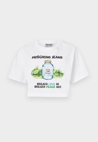 Hvit avkortet t-skjorte med grafikk av et glasskrukke med grønn beplantning. Svart og blå tekst med ordene "MOSCHINO JEANS" og fraser om kjærlighet og fred.