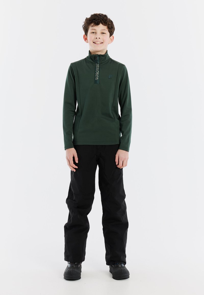 Pullover verde con maniche lunghe e colletto a mezza zip; pantaloni neri e stivali impermeabili. Design semplice, texture liscia e senza motivi visibili.
