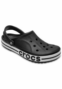 Czarne klapki Crocs z otworami wentylacyjnymi, biała podeszwa z czarnymi paskami i regulowanym paskiem na pięcie.