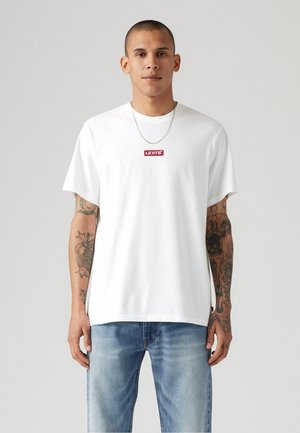 Weißes Baumwoll-T-Shirt mit Rundhalsausschnitt und kurzen Ärmeln, mit einem roten Levi's-Logopatch auf der Vorderseite. Lässige Passform.