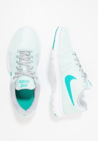 Scarpe da corsa di un blu chiaro con una tomaia texturizzata, lacci grigi e suole bianche. Presentano un caratteristico swoosh teal e un collo imbottito.