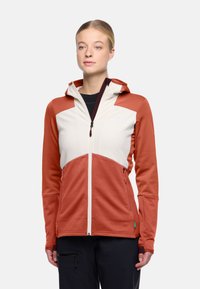 Giacca con cappuccio caratterizzata da una combinazione di colori terracotta e crema con tessuto testurizzato, chiusura con zip frontale e due tasche laterali.