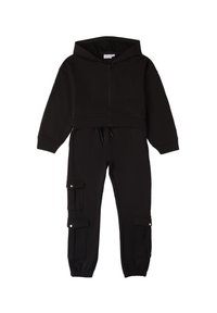 Sudadera corta negra con cremallera frontal y cordón; combinada con pantalones ajustados que tienen bolsillos de carga y puños elásticos.