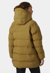 Parka acolchada en verde olivo con capucha, que presenta líneas horizontales cosidas y una textura suave. La longitud se extiende por debajo de la cintura.