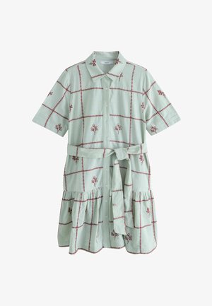 Vaaleanvihreä lyhythihainen paitamekko, jossa punaiset ommellut ruudut ja kukkaiskuvioita, nappikiinnitys edessä, vyötärön solmimisnauha ja röyhelöhelma.