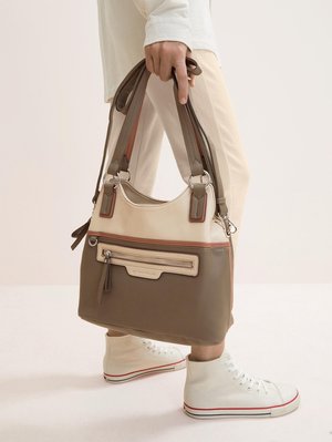 Tasche aus cremefarbenem, beigem und braunem Material, mit zwei Griffen, einer vorderen Reißverschlusstasche und kontrastierenden Akzenten. Strukturierte Oberfläche.