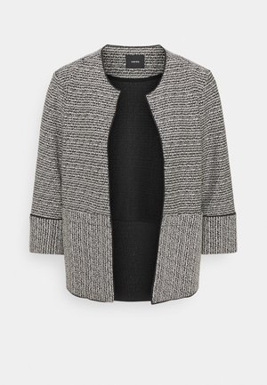 Mustavalkoinen tweed-takki, jossa on pyöreä pääntie, pitkät hihat ja avoin etuosa. Sisältää tekstuuripinnan ja kiinteän mustan sisäpuolen.