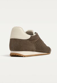 Baskets en suède marron avec un dessus en maille, talon en cuir blanc, semelle textur�ée et design à profil bas.