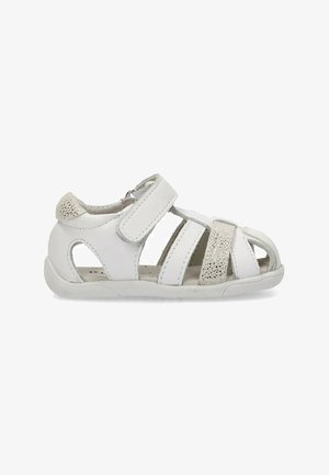 Sándalias de cuero blanco con acentos suaves y texturizados, correas de Velcro ajustables, diseño de punta abierta y suela de goma flexible.