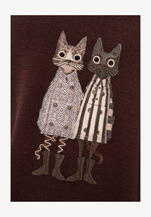 Dzianinowy sweter z dwoma haftowanymi kotami. Jeden ma na sobie płaszcz w jodełkę, drugi w paski, obaj z ozdobnymi butami. Ciemne tło.