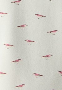 Un tessuto leggero con uno sfondo crema presenta un motivo ripetuto di piccoli uccelli rosa con accenti verdi e dettagli fini, creando un design delicato.
