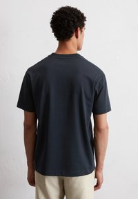 Czarna granatowa koszulka z krótkim rękawem z okrągłym dekoltem, wykonana z miękkiego materiału, charakteryzująca się prostym wzorem i gładką teksturą z tyłu.