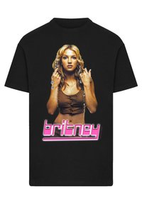 Zwarte t-shirt met een grafische afbeelding van een vrouw met lang haar, die een bruine top draagt, en de tekst "britney" in het roze onder de afbeelding.