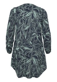 Tunique à manches longues en tissu bleu marine, ornée d'un motif floral vert clair et offrant une coupe décontractée avec un ourlet arrondi et des manches retroussées.