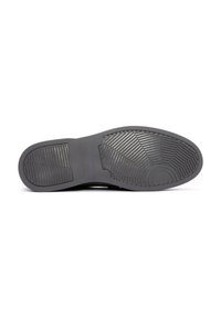 Semelle de chaussure en caoutchouc noir avec un motif texturé, comportant une zone centrale lisse et des rainures pour la traction. Design léger et flexible.