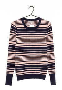 Żebrowany sweter w różowo-granatowe paski, z okrągłym dekoltem i długimi rękawami. Zawieszony na czarnym haczyku na białym tle.