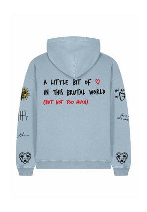 Hoodie bleu clair avec une poche avant, présentant un texte noir et rouge, des graphiques de soleil et de cœur. Le texte dit "UN PETIT PEU DE ♥ DANS CE MONDE BRUTAL".