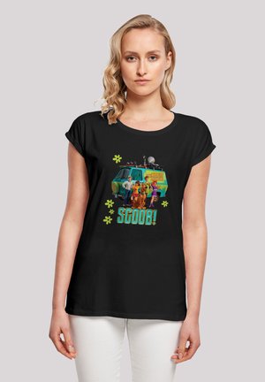 Black t-shirt featuring a graphic of the Mystery Machine and characters from Scooby-Doo, with colorful text “SCOOB!” and green accents.