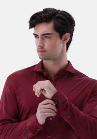 Bordeaux Langarmhemd mit tailliertem Kragen, knopfbaren Manschetten und weicher Textur; verfügt über einen Slim-Fit und subtilen Glanz.