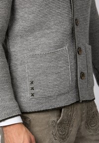 Grauer Strickcardigan mit strukturiertem Finish, ausgestattet mit Holzknöpfen und zwei aufgesetzten Taschen mit dekorativen Steppdetails.