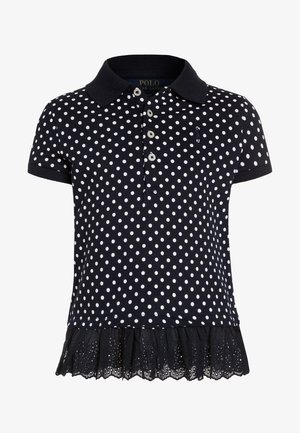 Polo de manga corta azul marino con lunares blancos, tapeta con botones y bajo con volante de encaje negro.