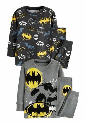 Kaksi sarjaa lasten pyjamaa, joissa on Batman-teemaisia kuvastoja. Ylähyllyssä on musta paita, jossa on monivärisiä Batman-logoja; housut ovat mustat. Alahyllyssä on harmaa paita, jossa on suuri keltainen Batman-logo roiskeakenteilla, yhdistettynä harmaisiin housuihin. Molemmat sarjat on valmistettu pehmeästä kankaasta.