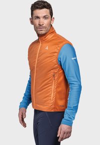 Orange isolierte Weste mit hohem Kragen, mit Reißverschlüssen versehenen Taschen und blauen strukturierten Ärmeln. Markenlogo auf der Brust und dem Ärmel sichtbar.