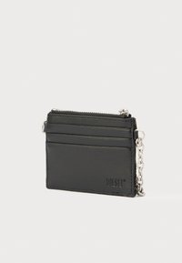 Μαύρο δερμάτινο πορτοφόλι με ασημένια αλυσίδα. Διαθέτει κλείσιμο με φερμουάρ και πολλαπλές θήκες για κάρτες. Λείο υφή με ανάγλυφη λεπτομέρεια λογότυπου.