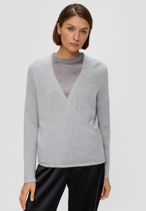 Grau gestrickte Wickeljacke mit langen Ärmeln, V-Ausschnitt und subtilen Glitzer, kombiniert mit einem grauen enganliegenden Top und schwarzen satinierten Hosen.