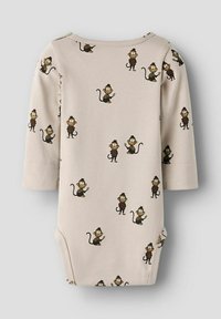 Body à manches longues beige clair avec un motif de singe en cartoon répétitif. Matière en coton doux avec un col rond et des fermetures à pression.
