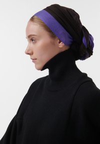 Zwarte coltrui, met een gestructureerde brei. De hoofddoek bestaat uit donkerbruin en paarse stof, met een gelaagd, gedraaid ontwerp.