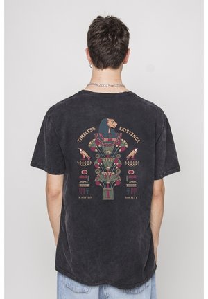 Czarna koszulka bawełniana z graficznym nadrukiem z tyłu, przedstawiającym motywy egipskie, kolorowe wzory oraz tekst "TIMELESS EXISTENCE KAOTIKO SOCIETY."