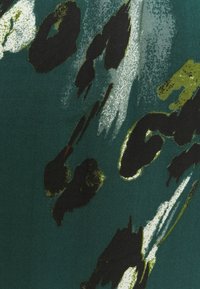 Stoff mit einem dunkelgrünen Grund, der abstrakte Muster in Schwarz, Weiß und Olivgrün zeigt. Glatte Textur mit subtiler Glanzigkeit.