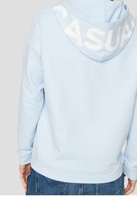 Sudadera azul clara con una capucha amplia que presenta la palabra "CASUAL" en letras blancas y en negrita. Fabricada con una suave mezcla de algodón.