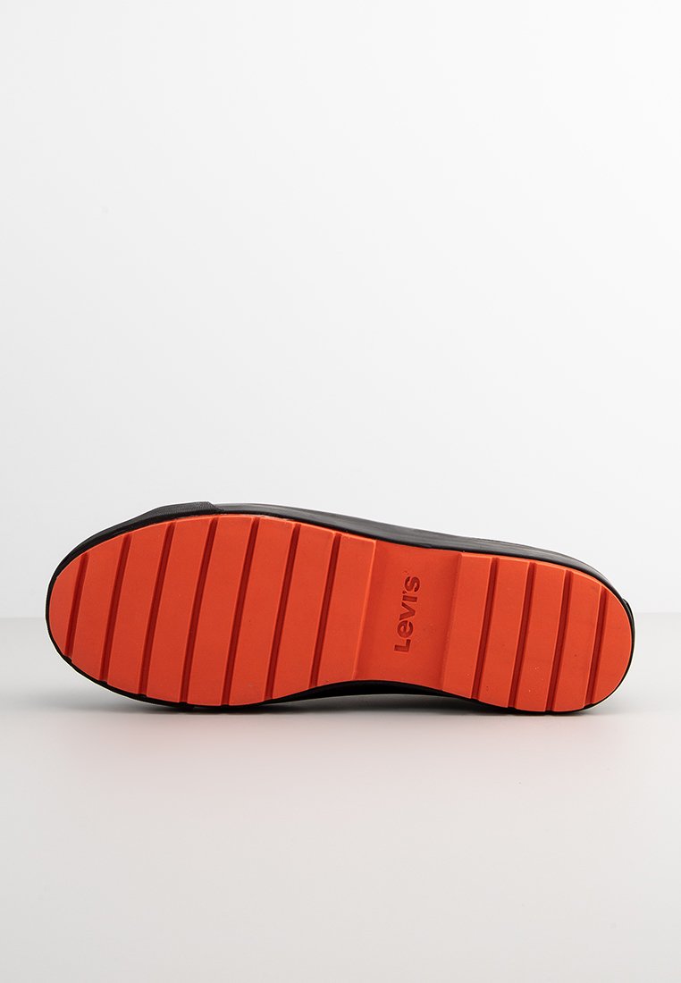 Suola di un sneaker nera con una suola in gomma arancione texture caratterizzata da scanalature orizzontali e il nome del marchio "Levis" embossato.