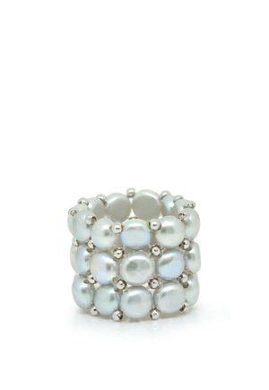 Large bague composée de trois rangées de perles blanches rondes reliées par de petites perles argentées sur un fond blanc.