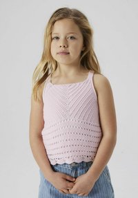 Camiseta sin mangas de ganchillo en rosa claro con patrones diagonales y dobladillo con puntilla. Combinada con shorts de mezclilla azul a rayas.