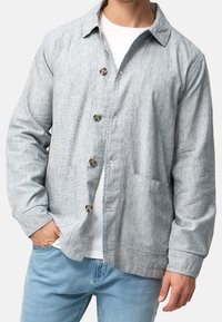 Light gray button-up jacket made of textured fabric, featuring a classic collar, two front pockets, and a relaxed fit design.