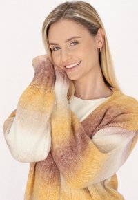 Cardigan lavorato a maglia con un motivo sfumato in tonalità di crema, giallo e marrone. Vestibilità oversize e texture morbida.