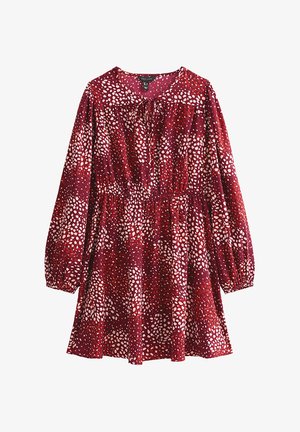Robe rouge à manches longues, taille élastique et détail de col noué. Motif de taches blanches et rose clair sur un fond sombre.