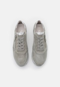 Harmaat mokkakengät, joissa on rei'itetty pinta, hopeiset yksityiskohdat, nauhakiinnitys ja sivuvetoketju. Pyöristetty kärki ja pehmeä sisäpohja.