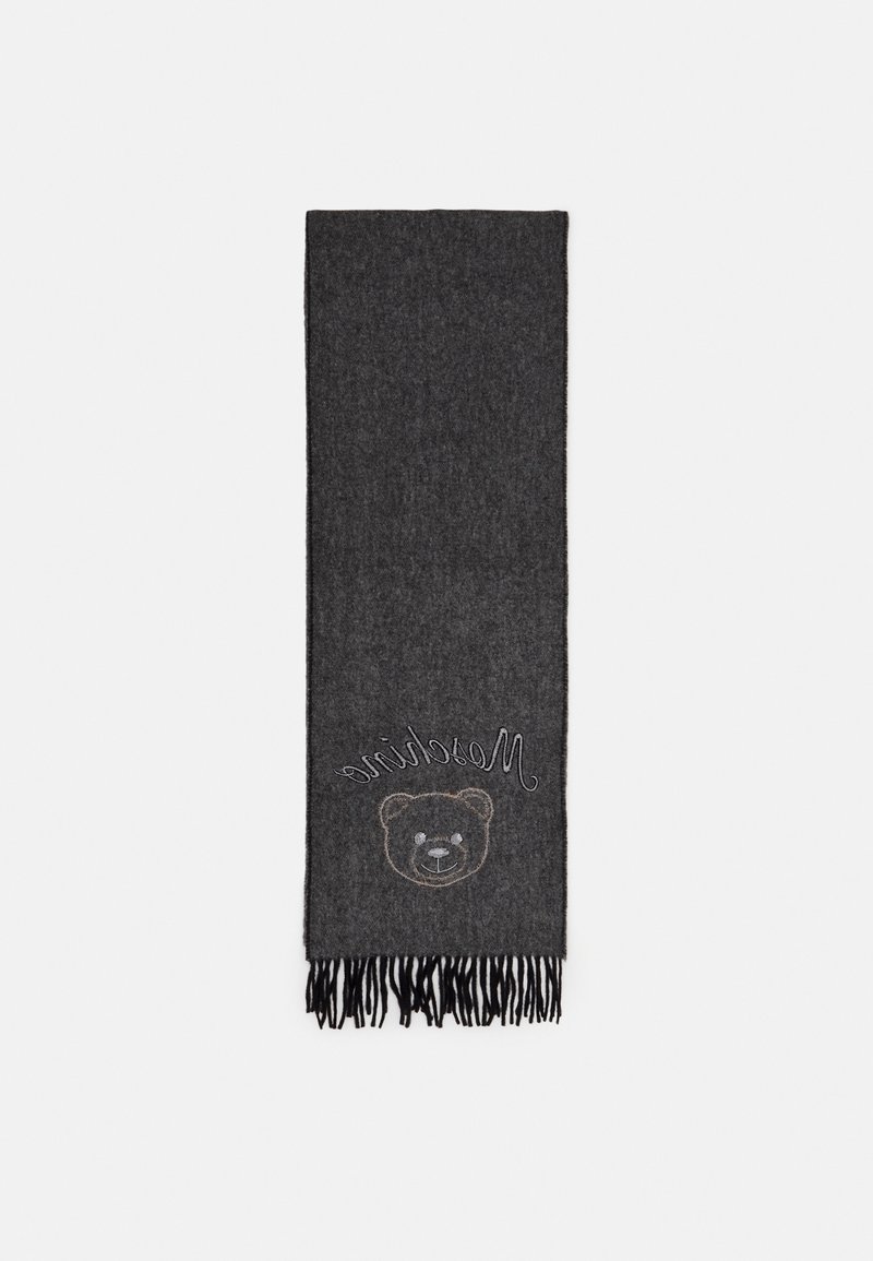Écharpe en laine gris foncé avec des extrémités à franges, ornée d'un visage d'ours souriant cousu et du texte en cursive « Moschino » près d'un bord.