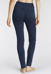 Dunkelblaue Stretch-Jeans mit hoher Taille, slim Fit und glatter Textur. Keine sichtbaren Beschläge oder Verzierungen.
