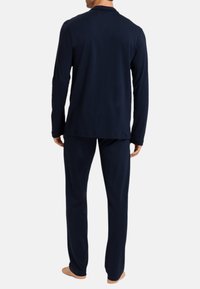 Haut à manches longues bleu marine et pantalon assorti en tissu doux, offrant une coupe décontractée et des détails de couture minimalistes.